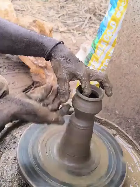 Manos de un alfarero levantando una pieza en el torno